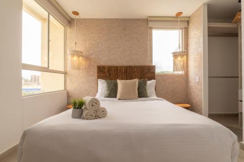 a large white bed in a room with windows at Apartment with a Pool and Parking 2Bed in Cartagen in Cartagena de Indias