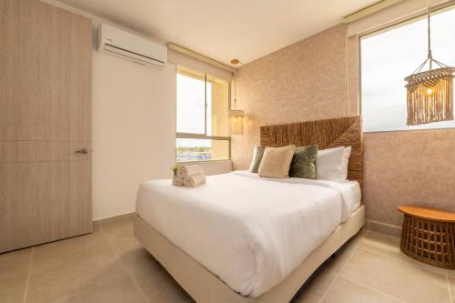 a bedroom with a large white bed and a window at Apartment with a Pool and Parking 2Bed in Cartagen in Cartagena de Indias
