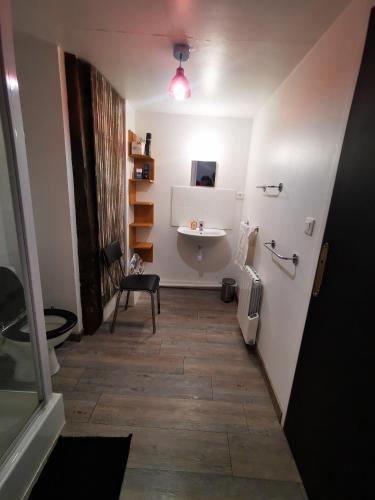 - un couloir avec une salle de bains pourvue d'un lavabo et d'une table dans l'établissement Gîte 3 chambres, à Saint-Gonlay