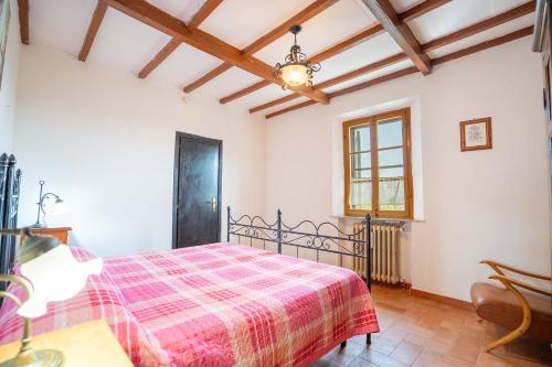 una camera con un letto con una coperta rossa a scacchi di VILLA MIMOSA - Il Castagneto Country Retreat a Pozzuolo