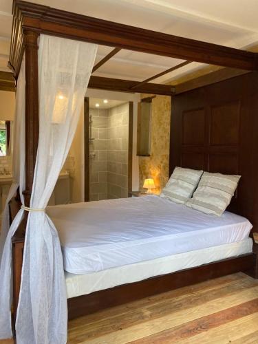 une chambre avec un lit à baldaquin dans l'établissement Gîte du banc de scie, à Ceton