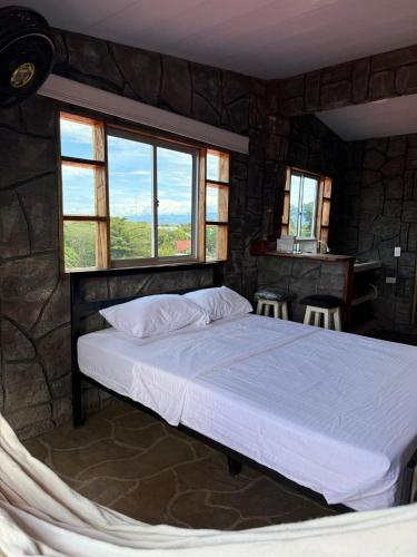 Un dormitorio con una cama en una habitación con ventanas. en Hidden Gem in the desert, en Aipe