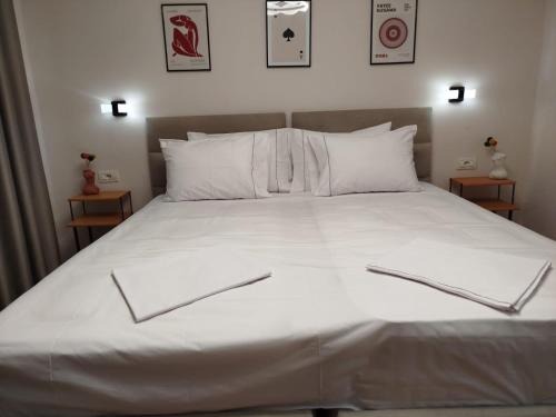 a bed with white sheets and pillows on it at Oda Zen Albania in Tirana