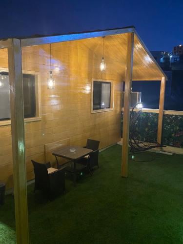 a patio with a table and chairs and a building at كوخ خزامى الباحة in Al Baha