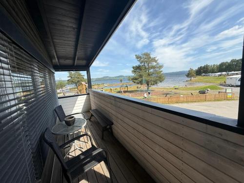 a balcony with two chairs and a table with a view of the water at Sveastranda Camping in Gullor