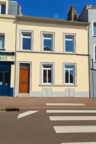une maison blanche avec une porte rouge dans une rue dans l'établissement Le 44 Saint-Louis, à Boulogne-sur-Mer