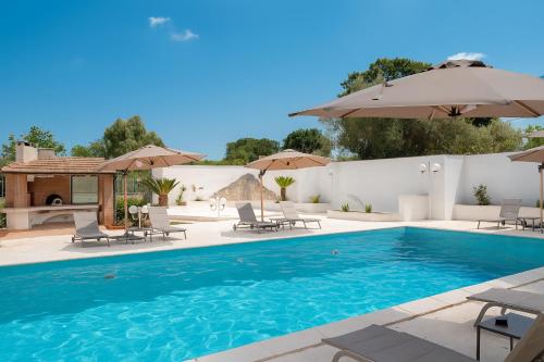 a swimming pool with chairs and umbrellas at Castellinaria Holiday in Castellana Grotte