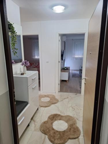 a white bathroom with a sink and a mirror at Apartman L&S in Doboj
