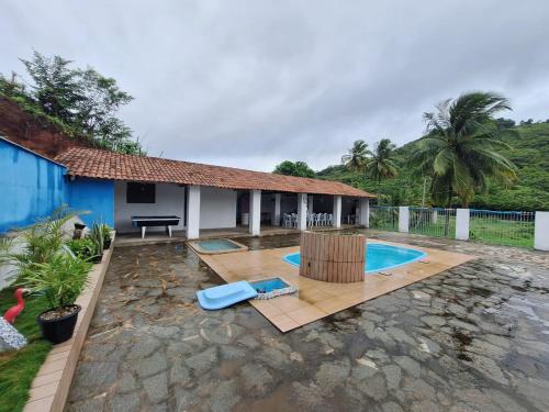 a villa with a swimming pool and a house at Chácara Mergulho Azul in Belém