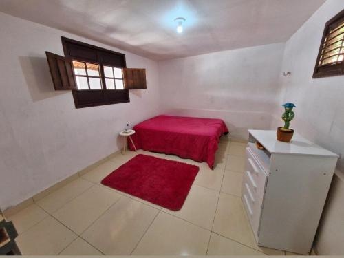 a bedroom with a red bed and a red rug at Chácara Mergulho Azul in Belém