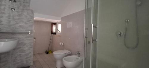 a bathroom with a toilet and a sink and a shower at Le Pigne casa vacanze. in Pollica