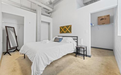 a white bedroom with a bed and a table at Downtown Loft l Cleveland l Parking l Cafe in Cleveland