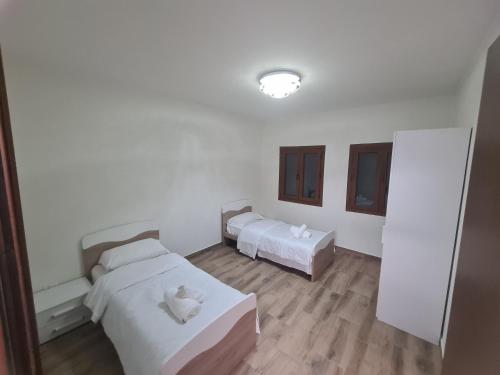 two beds in a room with white walls and wooden floors at Agriturismo Ca Novak Venezia in Spinea