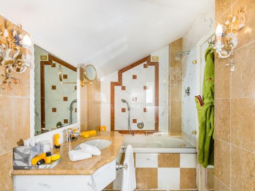 a bathroom with a sink and a bath tub at Hotel Villa e Palazzo Aminta in Stresa