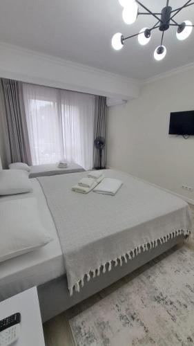 a white bedroom with a large bed and a window at Air-Moldova Family in Chişinău