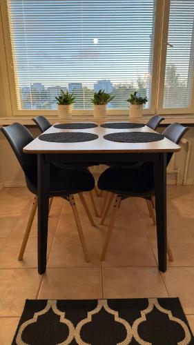 a dining room table with chairs and a window at Apartment Pilvenveikko in Kokkola