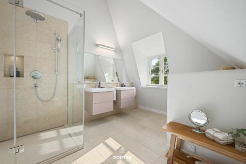 une salle de bain avec douche et lavabo dans l'établissement Ferienhaus ReetCottage 24 Dörphof, à Dörphof