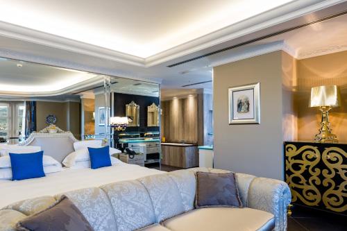 a bedroom with a large bed and a couch at Hotel Villa e Palazzo Aminta in Stresa