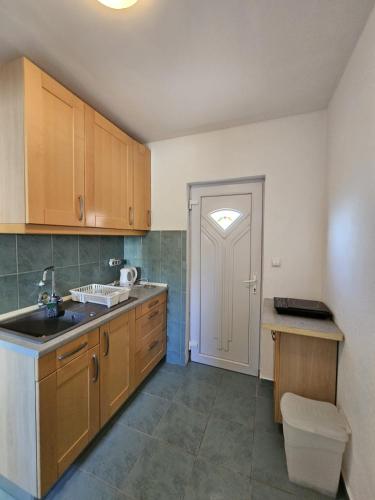 a kitchen with wooden cabinets and a sink and a door at Maja in Kolan