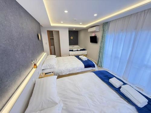a hotel room with three beds and a window at 浅草駅徒歩8分 浅草寺すぐそばの仲見世散策ステイ DqcSoY in Tokyo