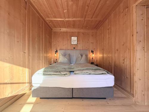 a bedroom with a large bed in a wooden wall at Haus Carolus in Elbigenalp