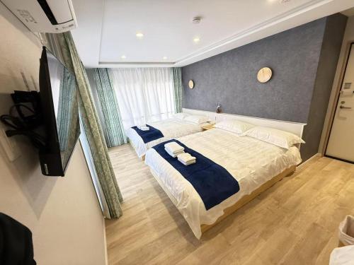 a bedroom with a large bed with blue sheets at 浅草駅徒歩8分 浅草寺すぐそばの仲見世散策ステイ DqcSoY in Tokyo