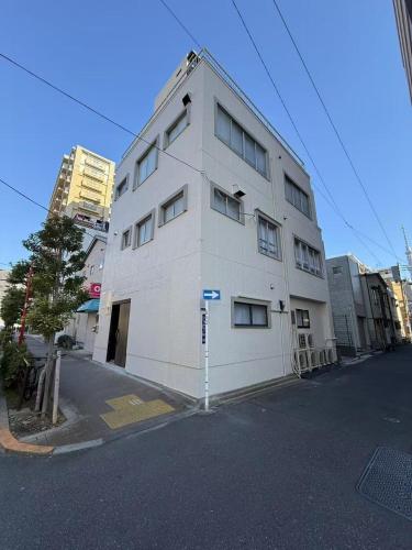 a white building on the side of a street at 浅草駅徒歩8分 浅草寺すぐそばの仲見世散策ステイ DqcSoY in Tokyo