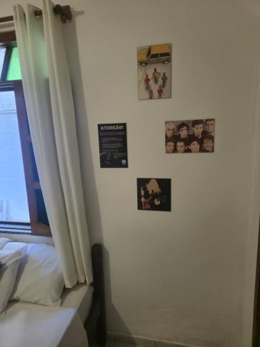 a bedroom with a bed and posters on the wall at Pousada do Rock in Arraial d'Ajuda