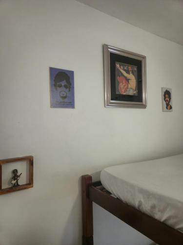 a bedroom with two pictures on the wall and a bed at Pousada do Rock in Arraial d'Ajuda