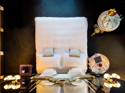 a bed with pillows on top of a glass table at Hotel Villa e Palazzo Aminta in Stresa