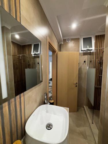 a bathroom with a white sink and a mirror at FanLex Summer House in Nea Kalikratia