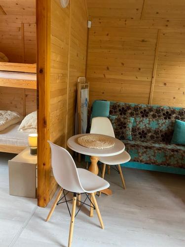 a room with a table and chairs and a bed at Plażowa Domki in Mielenko