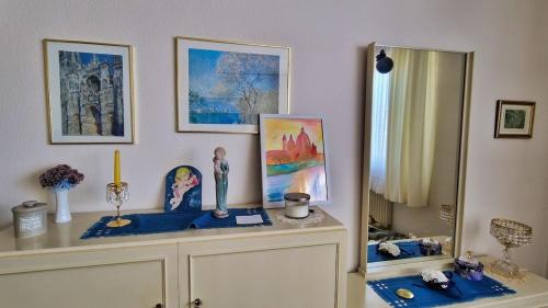 a cabinet with figurines on top of it with paintings at Vintage charm with comfort in Bernkastel-Kues