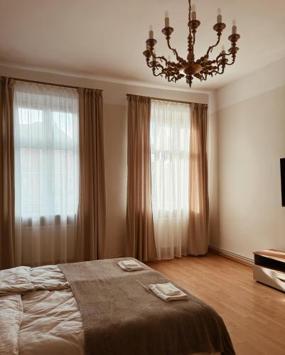 a bedroom with a bed and a chandelier at Apartament na Gnieźnieńskim Rynku in Gniezno