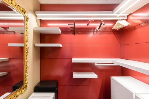 a red bathroom with white shelves and a mirror at Hotel Villa e Palazzo Aminta in Stresa