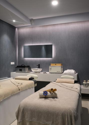 a room with three beds and a flat screen tv at Melia Lisboa Oriente Hotel in Lisbon