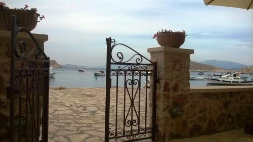 a gate to a house with a view of the water at Halkis Muses in Halki