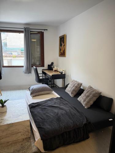 a bedroom with two beds and a table and a window at Le temple, moderne et élégant Cœur de Limoges in Limoges