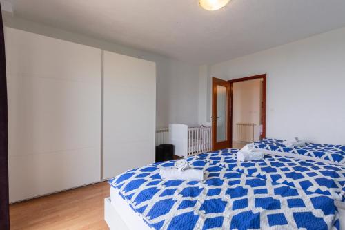 a bedroom with a blue and white comforter on a bed at Apartman Fonovici in Juraši