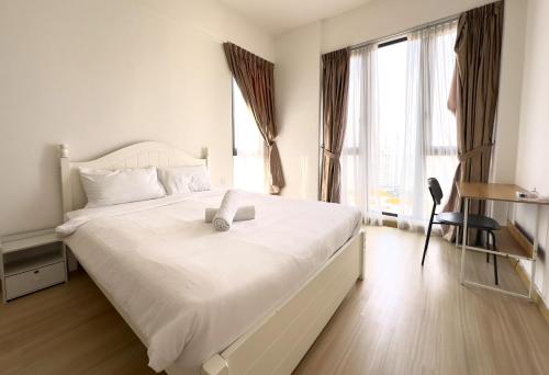 ein Schlafzimmer mit einem großen weißen Bett und einem Fenster in der Unterkunft Deluxe Seaview Suite Tripe Bed with bath tub 25 in Tanjong Tokong