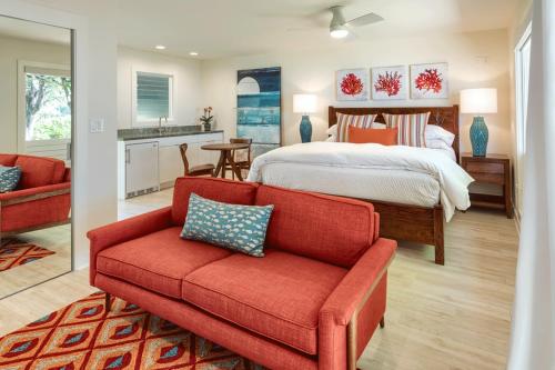 a bedroom with a bed and a red couch at Haena Beach House TVNC#1258 in Hanalei