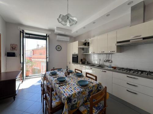 Corte San Giovanni - Alloggio per vacanza perfetta في فيتري: مطبخ مع طاولة مع كراسي وغرفة طعام