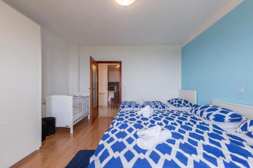 a bedroom with a blue and white bed with pillows at Apartman Fonovici in Juraši