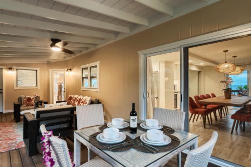 a dining room and living room with a table and chairs at Haena Beach House TVNC#1258 in Hanalei