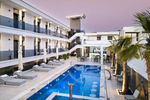 an image of a hotel with a pool and palm trees at Bareti Boutique Estate in Kallithea Halkidikis