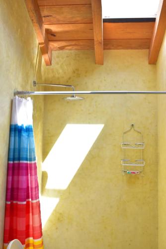 a bathroom with a rainbow shower curtain and a window at Las Casas Chiapas in San Cristóbal de Las Casas