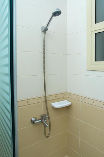 a shower with a shower head in a bathroom at Dream Palace Hotel in Ajman 