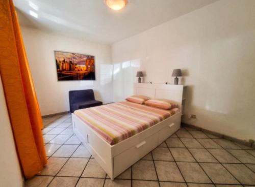a bedroom with a bed and a blue chair at Case Gemelle - CIR 0271 in Aosta