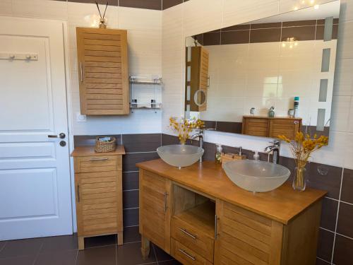 ein Badezimmer mit zwei Waschbecken und einem großen Spiegel in der Unterkunft Villa avec piscine in Landorthe