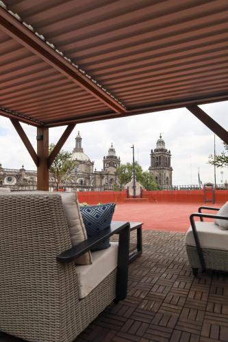 a patio with a table and chairs and a view of a city at CASA SAUTO 2 BR 2BA balcony Historic Building in Mexico City